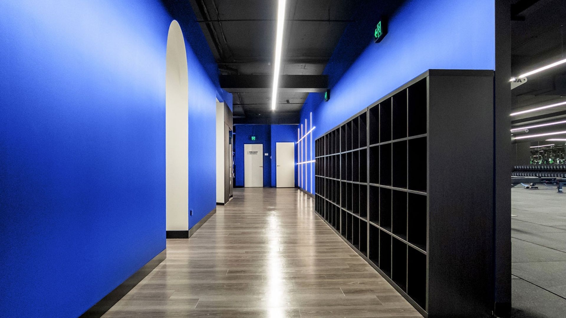 Blue corridor lined with lockers leading into the training floor